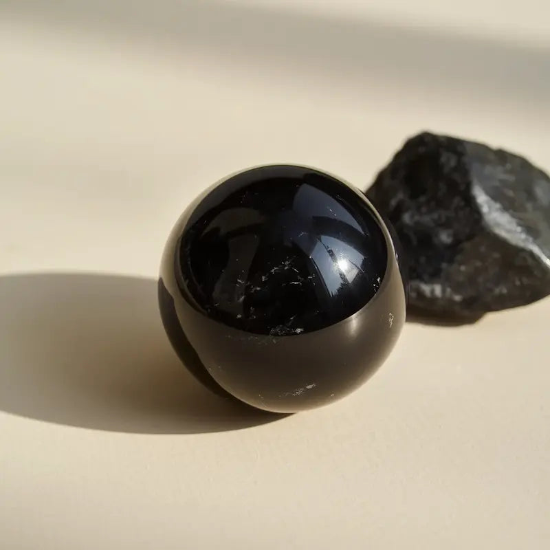 Polished black obsidian stone with glossy mirror-like surface